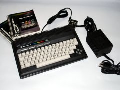 De Commodore +4 met gebruiksaanwijzing en voeding adapter.