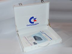 De binnen kant van de aktetas, ook met het Commodore logo. In de aktetas ligt een Commodore folder van de Commodore SFS 481 disk drive.
